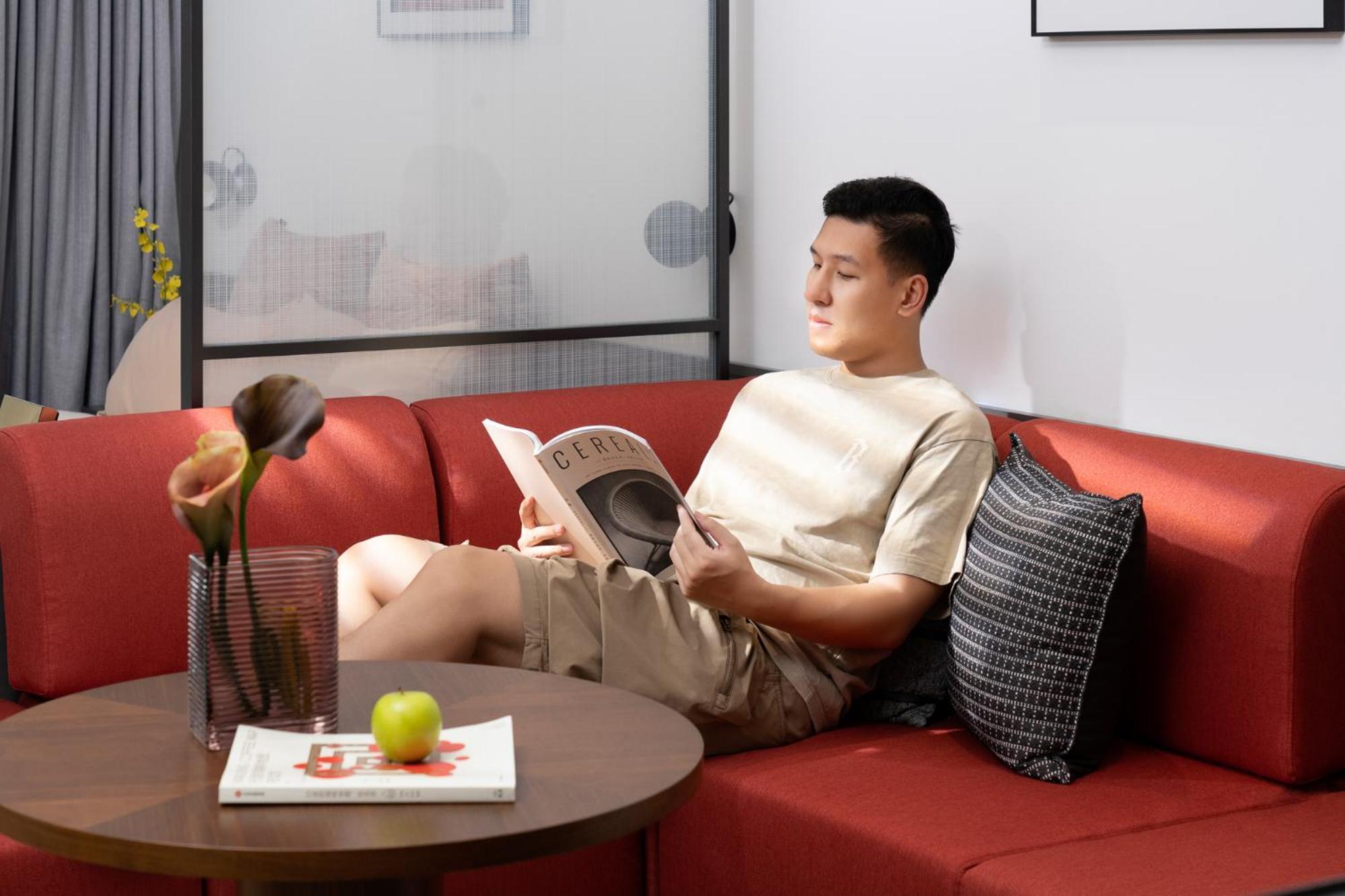 Base-Beijing Wangfujing Serviced Apartment- In Hutong &Bike Rental &Close To Forbidden City, Tian'Anmen Square &Subway Nearby &Free Coffee &Washing Machine,Kitchen &Restaurant Discount &English Speaking &High Speed Free Wifi Exterior foto A man reading a book on a sofa